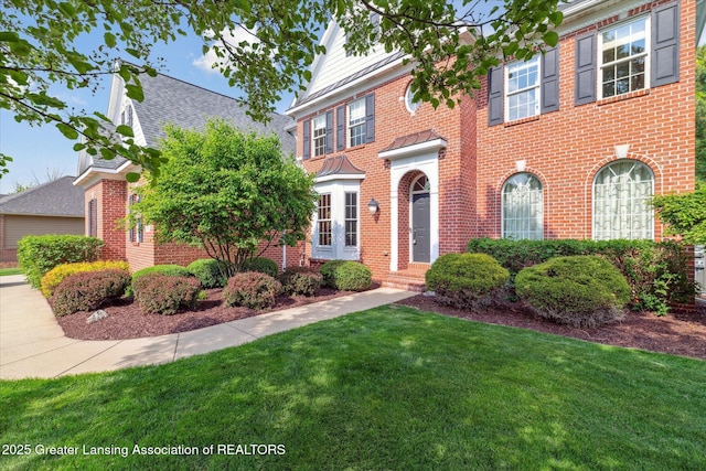 colonial home with a front lawn and brick siding