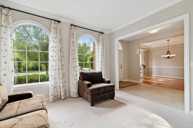 living area featuring ornamental molding, baseboards, tile patterned floors, a chandelier, and carpet floors
