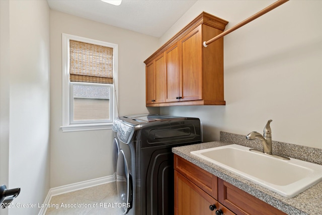 laundry room with cabinet space, baseboards, and tile patterned floors
