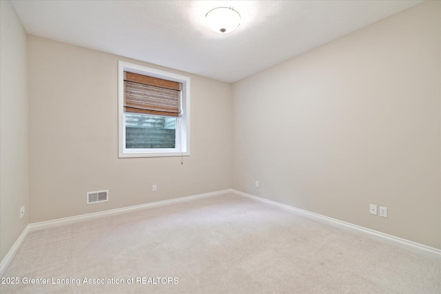 empty room featuring carpet and baseboards