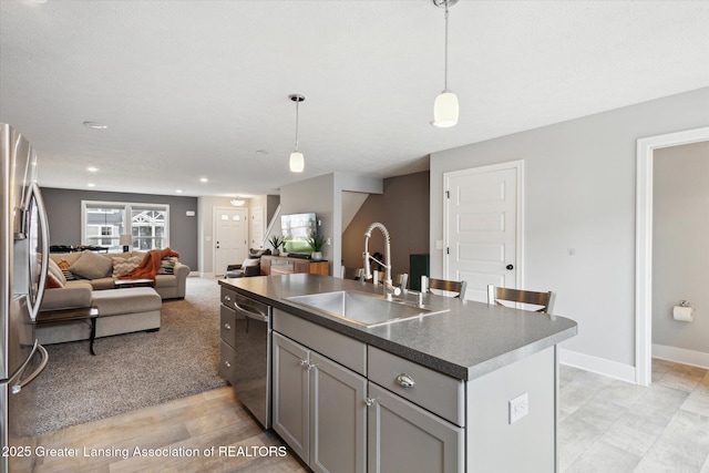 3842 Fossum Ln, Okemos, MI 48864 - kitchen with a sink, appliances with stainless steel finishes, open floor plan, gray cabinets, and a center island with sink