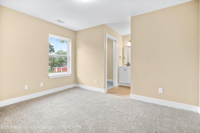 1229 W Saginaw St, Lansing, MI 48915 - spare room with light colored carpet and baseboards