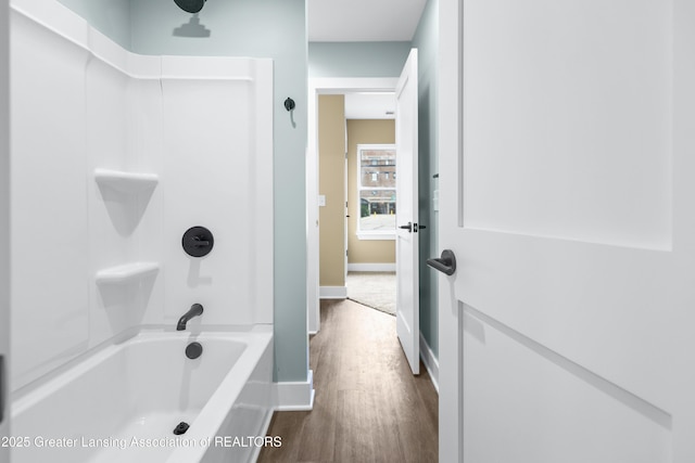 1229 W Saginaw St, Lansing, MI 48915 - bathroom featuring wood finished floors, shower / bath combination, and baseboards