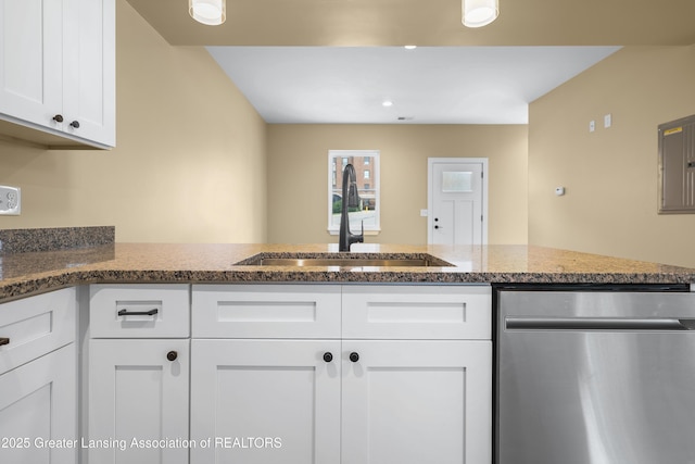 1229 W Saginaw St, Lansing, MI 48915 - kitchen featuring dishwasher, a sink, white cabinets, dark stone counters, and a peninsula