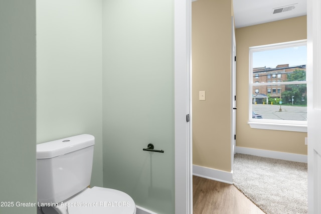 1229 W Saginaw St, Lansing, MI 48915 - bathroom featuring baseboards, toilet, and wood finished floors