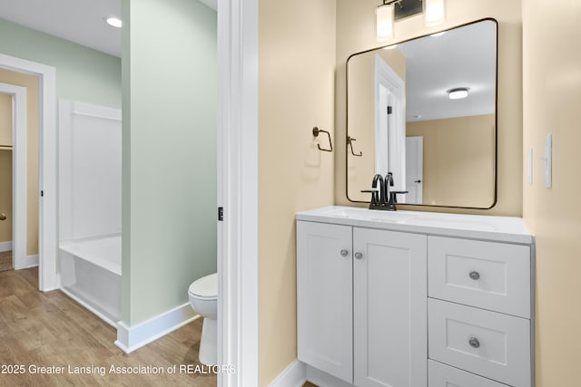 1229 W Saginaw St, Lansing, MI 48915 - bathroom with wood finished floors, toilet, baseboards, and vanity