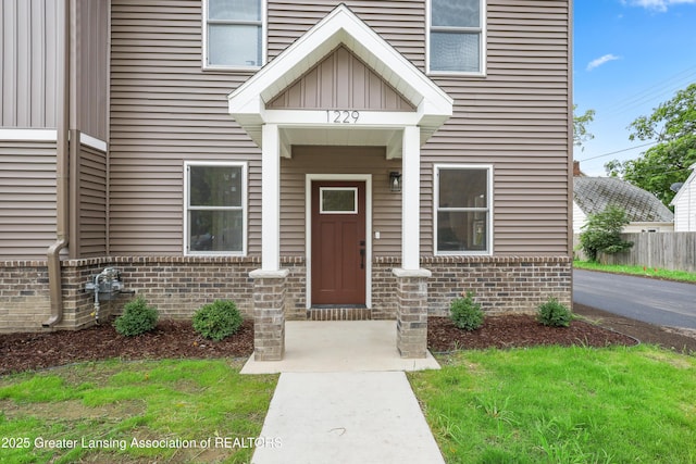 1229 W Saginaw St, Lansing, MI 48915 - doorway to property featuring brick siding and board and batten siding