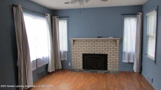 745 Roosevelt St, Mason, MI 48854 - unfurnished living room featuring a ceiling fan, plenty of natural light, a fireplace, and wood finished floors