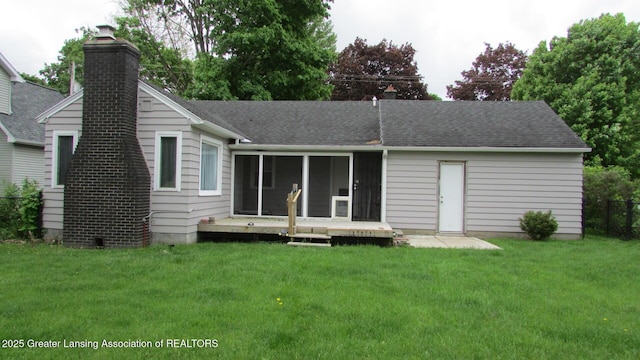 745 Roosevelt St, Mason, MI 48854 - rear view of house with a chimney, a lawn, a shingled roof, and a sunroom