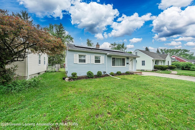 2018 Cooper Ave, Lansing, MI 48910 - view of front of property featuring solar panels, a front yard, and a chimney