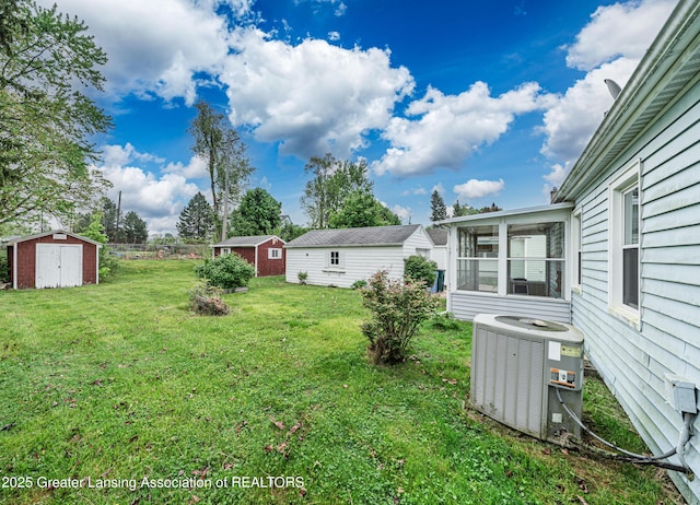 2018 Cooper Ave, Lansing, MI 48910 - view of green lawn with central air condition unit, a shed, a sunroom, and an outdoor structure