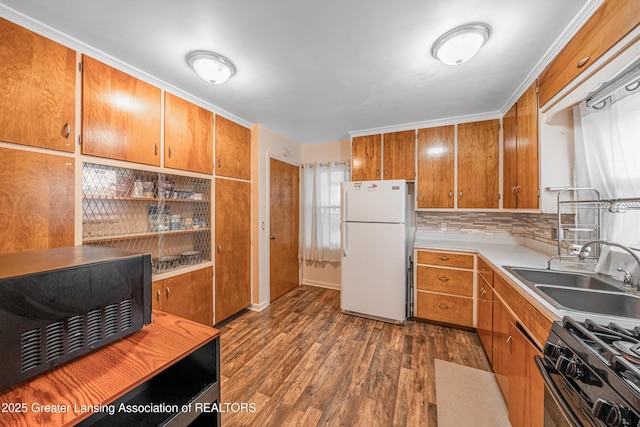 2018 Cooper Ave, Lansing, MI 48910 - kitchen with freestanding refrigerator, black gas range oven, a sink, dark wood finished floors, and light countertops