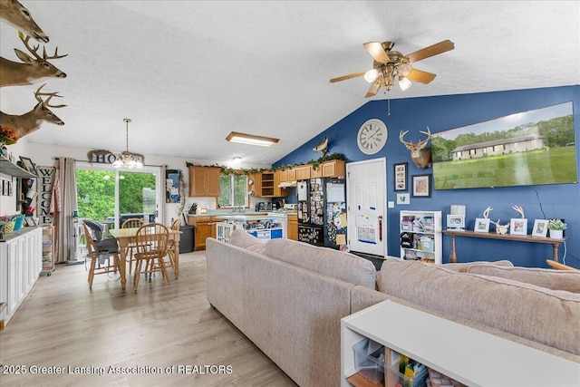 5669 Elm Rd, Olivet, MI 49076 - living room with a ceiling fan, light wood-style floors, a textured ceiling, and vaulted ceiling