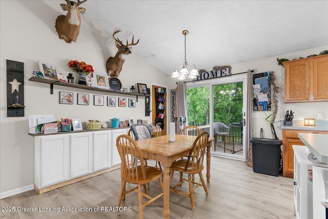 5669 Elm Rd, Olivet, MI 49076 - dining area with a chandelier, light wood-type flooring, and lofted ceiling