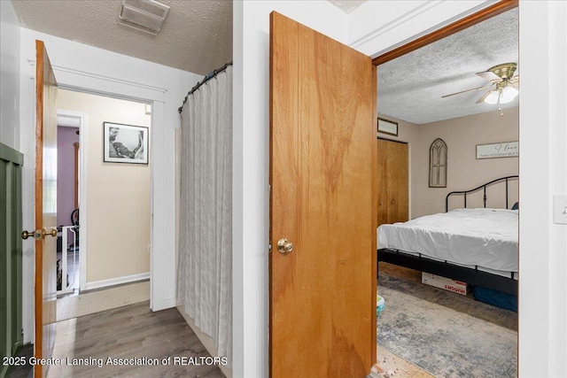 5669 Elm Rd, Olivet, MI 49076 - bedroom featuring a textured ceiling, wood finished floors, baseboards, and a ceiling fan