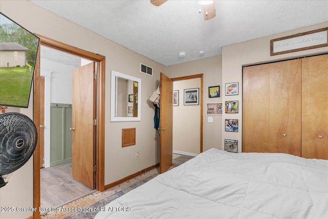 5669 Elm Rd, Olivet, MI 49076 - bedroom featuring wood finished floors, a closet, a textured ceiling, baseboards, and a ceiling fan