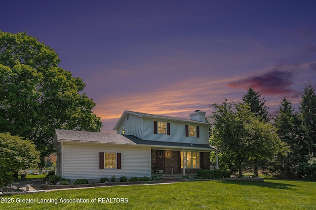 985 Ives Rd, Mason, MI 48854 - traditional home featuring covered porch, a chimney, and a lawn