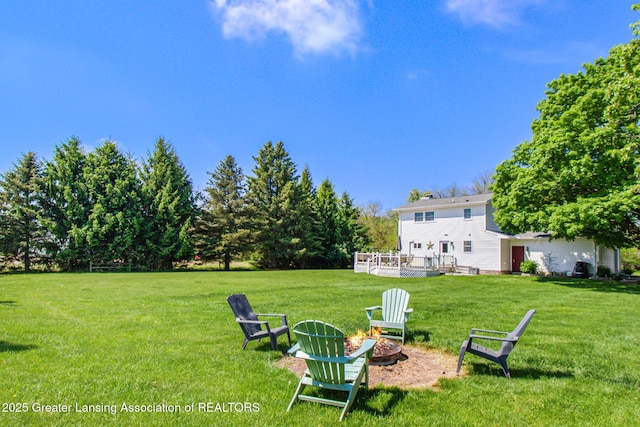 985 Ives Rd, Mason, MI 48854 - view of grassy yard featuring an outdoor fire pit and a deck