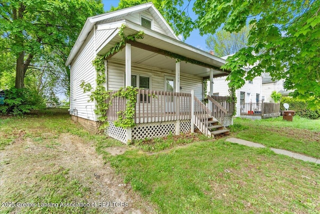 1200 W Lenawee St, Lansing, MI 48915 - shotgun-style home with a porch and a front lawn