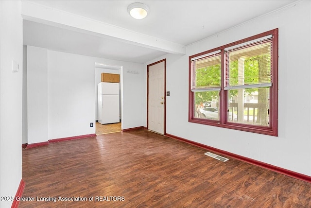 1200 W Lenawee St, Lansing, MI 48915 - spare room featuring beamed ceiling, baseboards, and wood finished floors