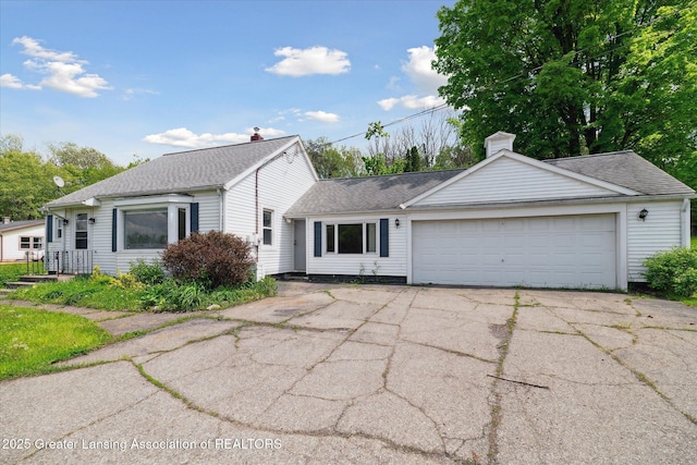 2468 Lansing Rd, Charlotte, MI 48813 - view of front of home with a garage, a chimney, asphalt driveway, and a shingled roof