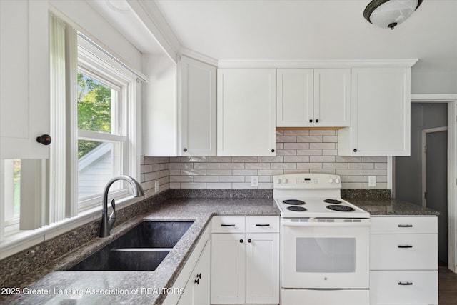 2468 Lansing Rd, Charlotte, MI 48813 - kitchen featuring electric range, a sink, tasteful backsplash, white cabinetry, and dark stone countertops