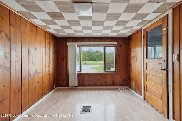 2468 Lansing Rd, Charlotte, MI 48813 - empty room with light wood-style floors, wooden walls, and baseboards