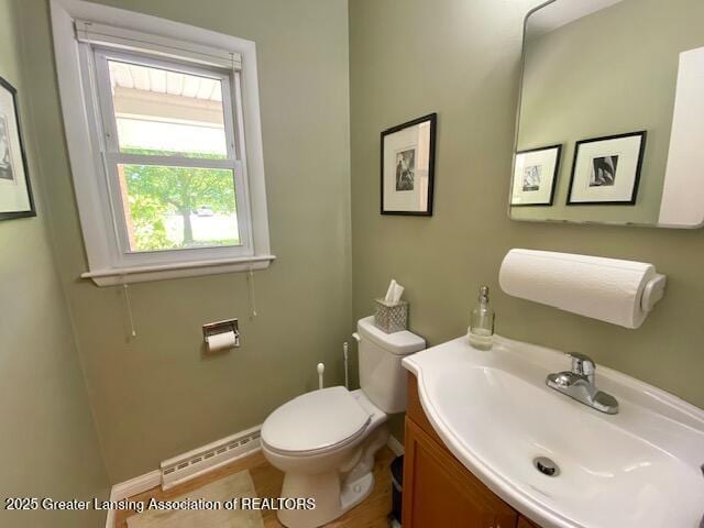 15426 Boichot Rd, Lansing, MI 48906 - bathroom with a baseboard radiator, toilet, baseboards, and vanity