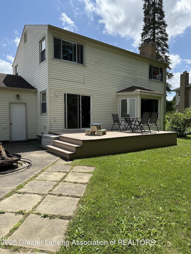 1211 W Thomas L Pkwy, Lansing, MI 48917 - rear view of house with a lawn, a wooden deck, and a chimney