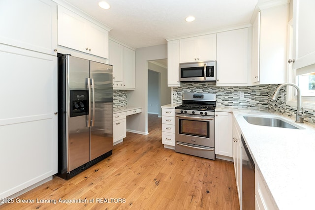 3979 Dayspring Ct, Okemos, MI 48864 - kitchen featuring stainless steel appliances, a sink, white cabinets, light wood-style floors, and recessed lighting