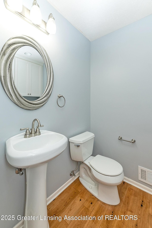 3979 Dayspring Ct, Okemos, MI 48864 - bathroom with baseboards, wood finished floors, and toilet