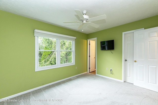 3979 Dayspring Ct, Okemos, MI 48864 - unfurnished bedroom with carpet flooring, baseboards, a ceiling fan, and a textured ceiling