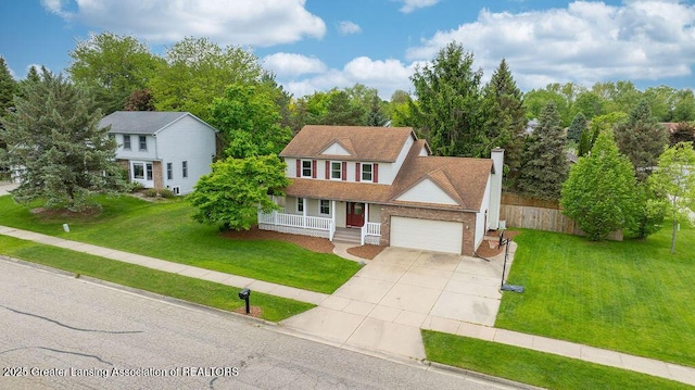 3979 Dayspring Ct, Okemos, MI 48864 - view of front facade with covered porch, concrete driveway, a garage, and a chimney
