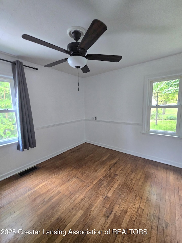 1427 Sheldon St, Lansing, MI 48906 - spare room with dark wood-style floors, plenty of natural light, ceiling fan, and baseboards