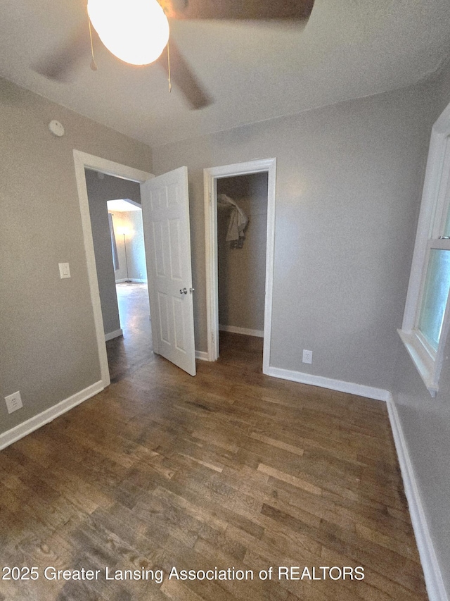1427 Sheldon St, Lansing, MI 48906 - unfurnished bedroom featuring wood finished floors, a walk in closet, and baseboards