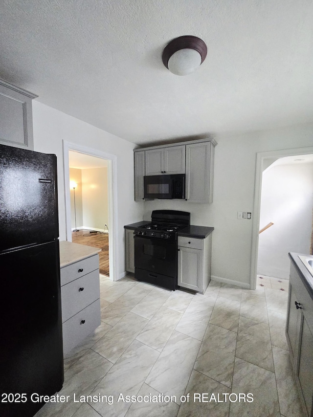 1427 Sheldon St, Lansing, MI 48906 - kitchen featuring black appliances, gray cabinetry, arched walkways, and baseboards