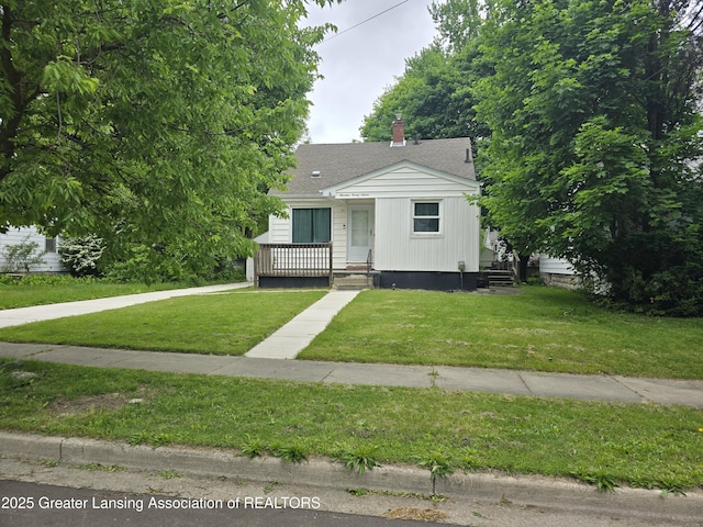 1427 Sheldon St, Lansing, MI 48906 - view of front of home featuring a front yard, roof with shingles, and a chimney