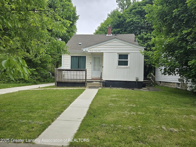1427 Sheldon St, Lansing, MI 48906 - bungalow-style house featuring a front yard, roof with shingles, and a chimney