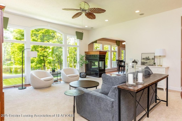 4655 Dimond Way, Dimondale, MI 48821 - living room featuring a multi sided fireplace, a ceiling fan, carpet floors, arched walkways, and recessed lighting