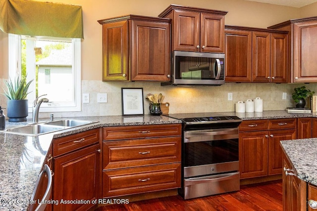 4655 Dimond Way, Dimondale, MI 48821 - kitchen featuring stainless steel appliances, a sink, dark wood-type flooring, stone countertops, and backsplash