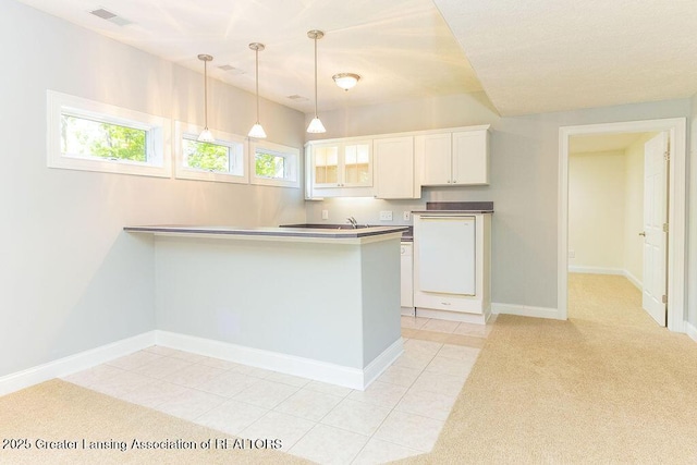 4655 Dimond Way, Dimondale, MI 48821 - kitchen with a peninsula, white cabinets, glass insert cabinets, pendant lighting, and baseboards