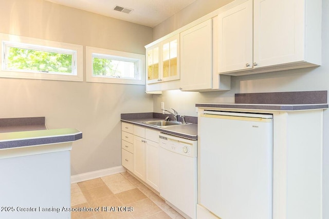 4655 Dimond Way, Dimondale, MI 48821 - kitchen featuring white dishwasher, a sink, baseboards, dark countertops, and glass insert cabinets