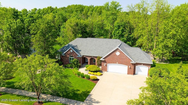 4655 Dimond Way, Dimondale, MI 48821 - traditional home with an attached garage, driveway, brick siding, and a front yard