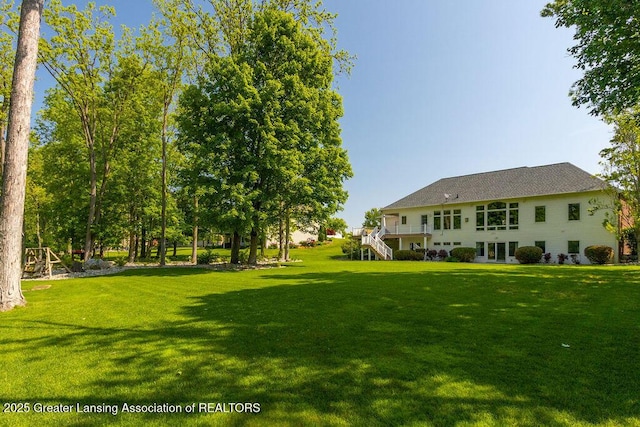 4655 Dimond Way, Dimondale, MI 48821 - view of grassy yard featuring stairway and a wooden deck