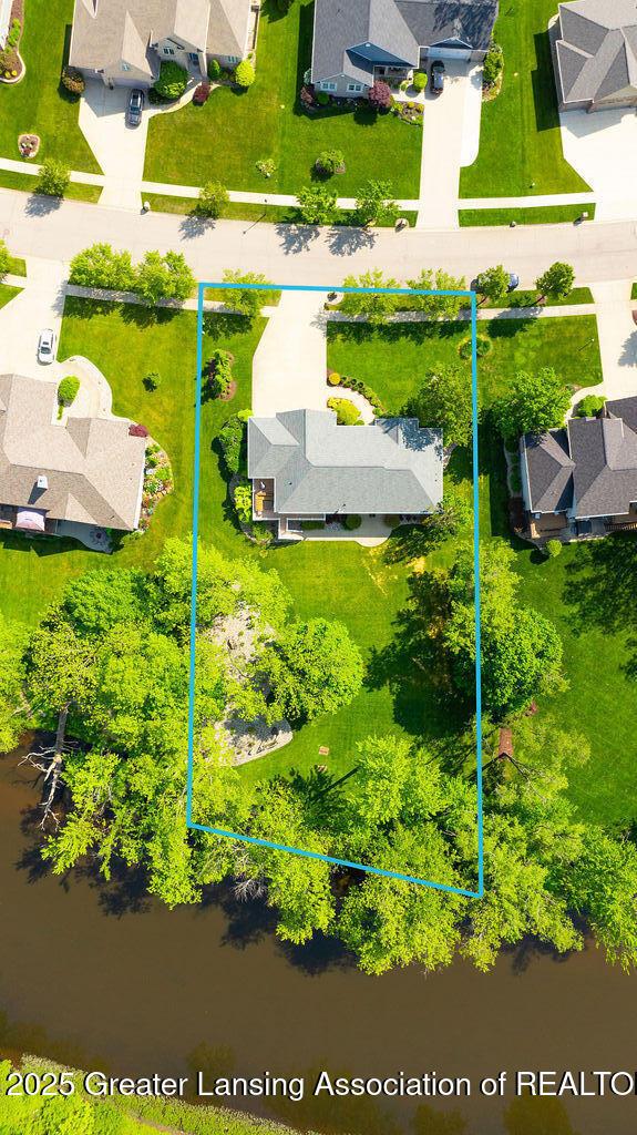 4655 Dimond Way, Dimondale, MI 48821 - aerial view of residential area featuring property parcel outlined and a large body of water