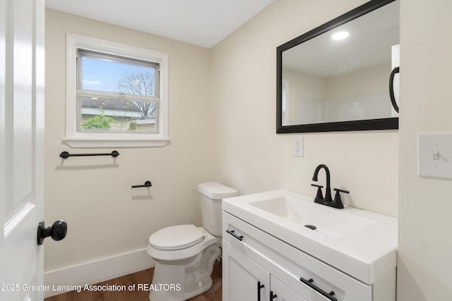 828 Backus St, Jackson, MI 49202 - half bath with wood finished floors, vanity, toilet, and baseboards