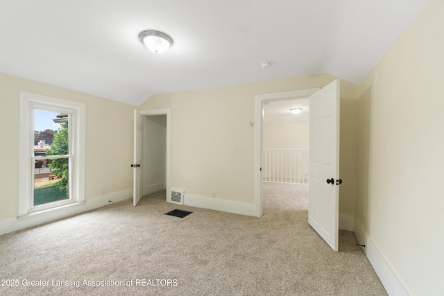 828 Backus St, Jackson, MI 49202 - unfurnished bedroom with vaulted ceiling, light colored carpet, and baseboards