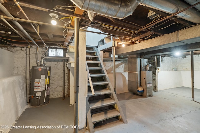 828 Backus St, Jackson, MI 49202 - below grade area featuring gas water heater, stairs, and heating unit