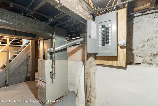 828 Backus St, Jackson, MI 49202 - unfinished below grade area featuring electric panel, heating unit, and stairs