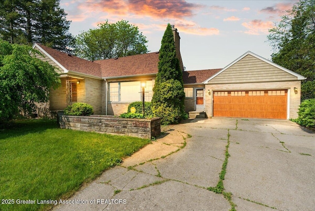 224 S Grace St, Lansing, MI 48917 - ranch-style house with concrete driveway, an attached garage, a chimney, a front lawn, and brick siding